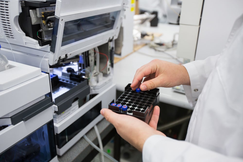 Research works on a machine in a lab.