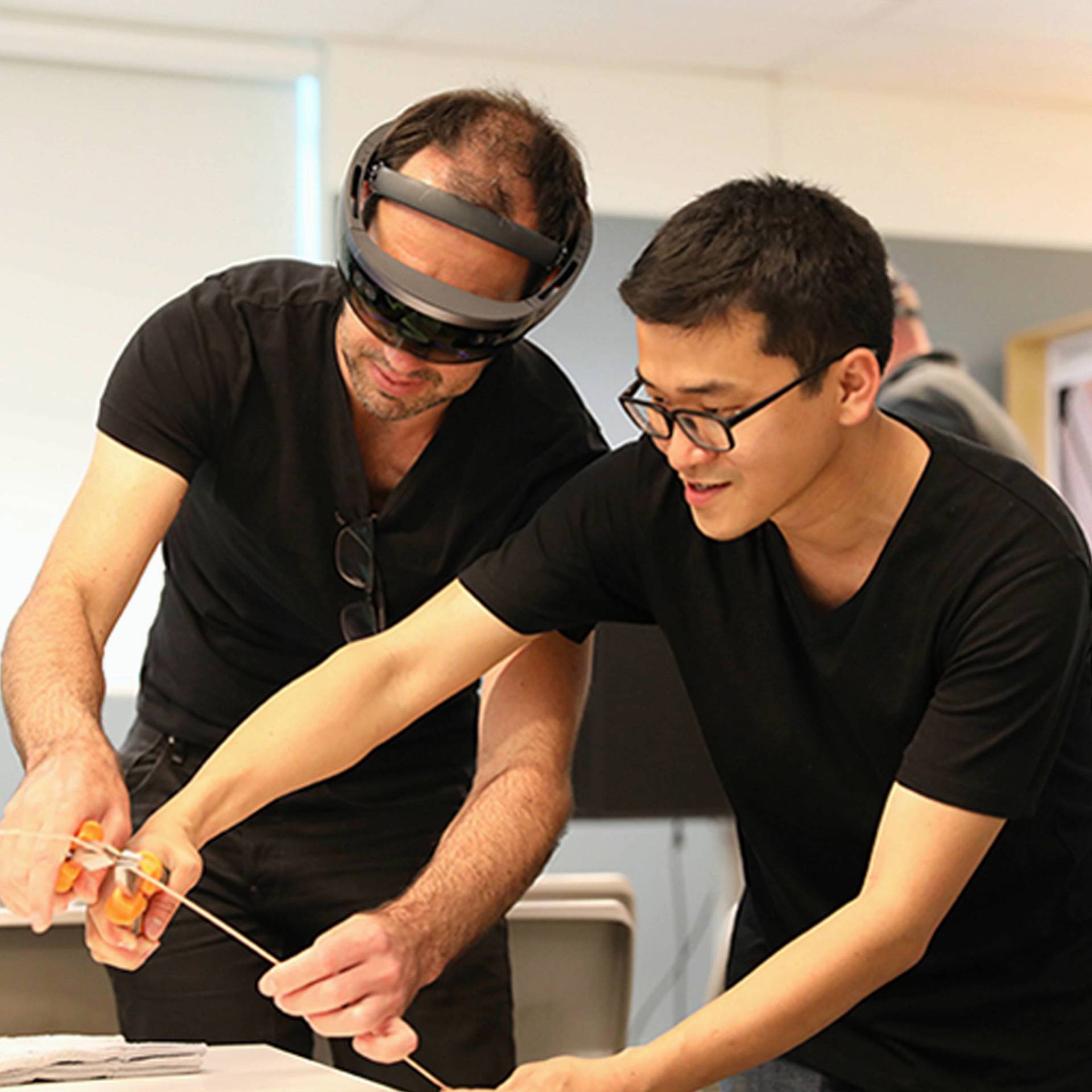 Two people using a HoloLens.